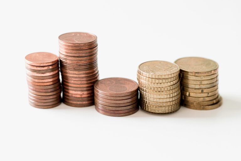 Stack of gold coins on a white surface reflecting the concept of financial growth and wealth accumulation through property investment